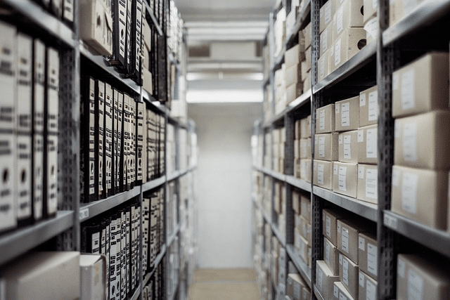 Storeroom archive of boxes and binders on tall metal shelves