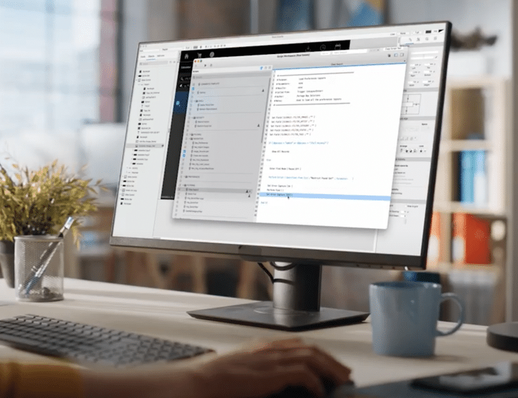 Computer screen in an open, airy office showing Claris FileMaker development of custom software.