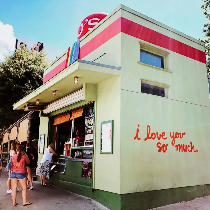 Photograph of a restaurant landmark in Austin, Texas, with an "i love you so much" mural painted on the sign.