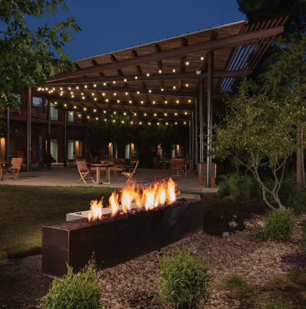 Photo of the courtyard at Lone Star Court in Austin, Texas, with evening lighting and a fire pit.