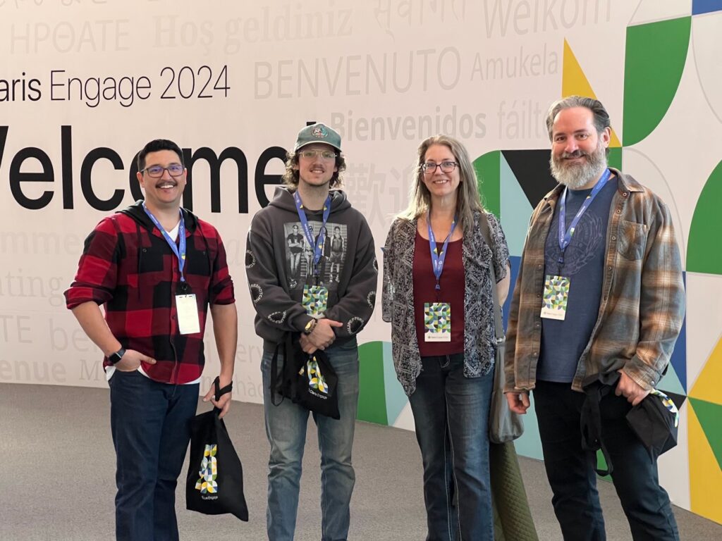 Jacob, Russell, Brandynn, and Xandon in front of the giant welcome display at Claris Engage 2024.