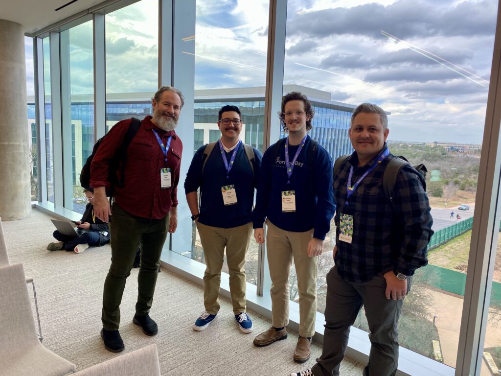 Photo of Xandon, Jacob, Russell, and Joe in front of a large picture window at Claris Engage 2024.