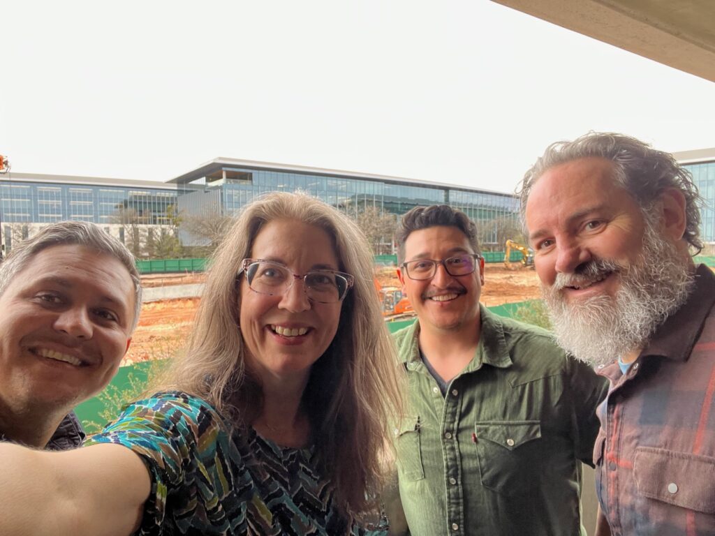 Selfie of Joe, Brandynn, Jacob, and Xandon, with the Austin Apple campus in the background.