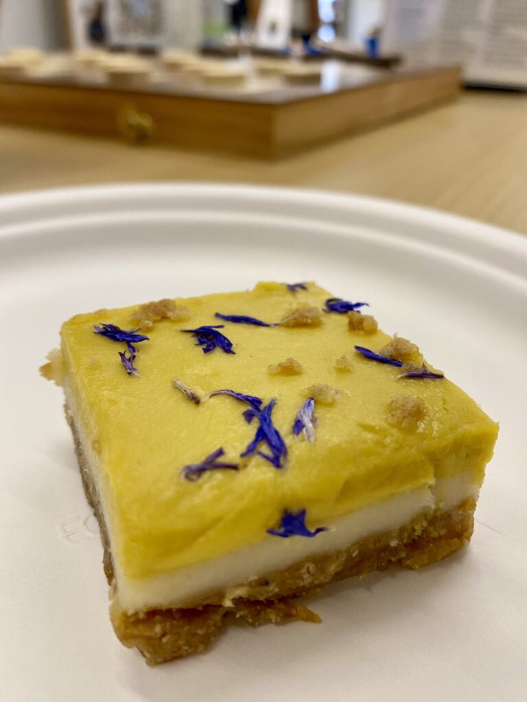 Photo of a delightful mango lime dessert at Claris Engage 2024 - vegan, gluten-free, and with edible purple flowers.