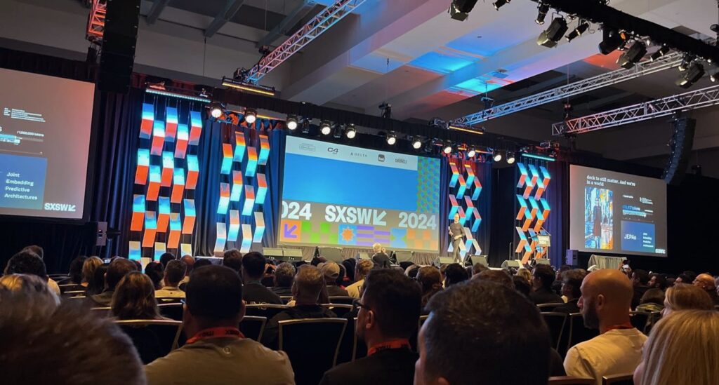 The main stage at SXSW, showing the crowd and three main screens.