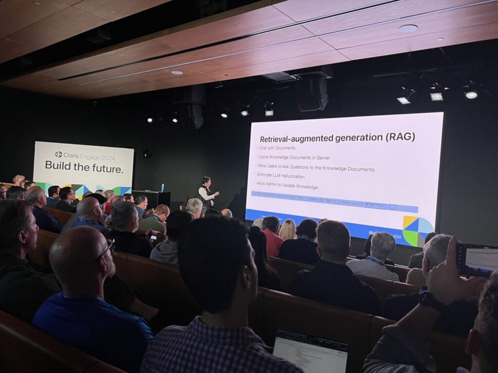 A Claris Engage session with a room full of people and an ongoing presentation.