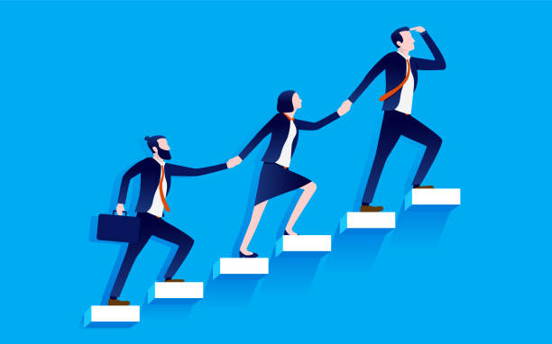 Three people, organized in the pattern man - woman - man, dressed in business atire. They are holding hands and walking up a flight of steps.